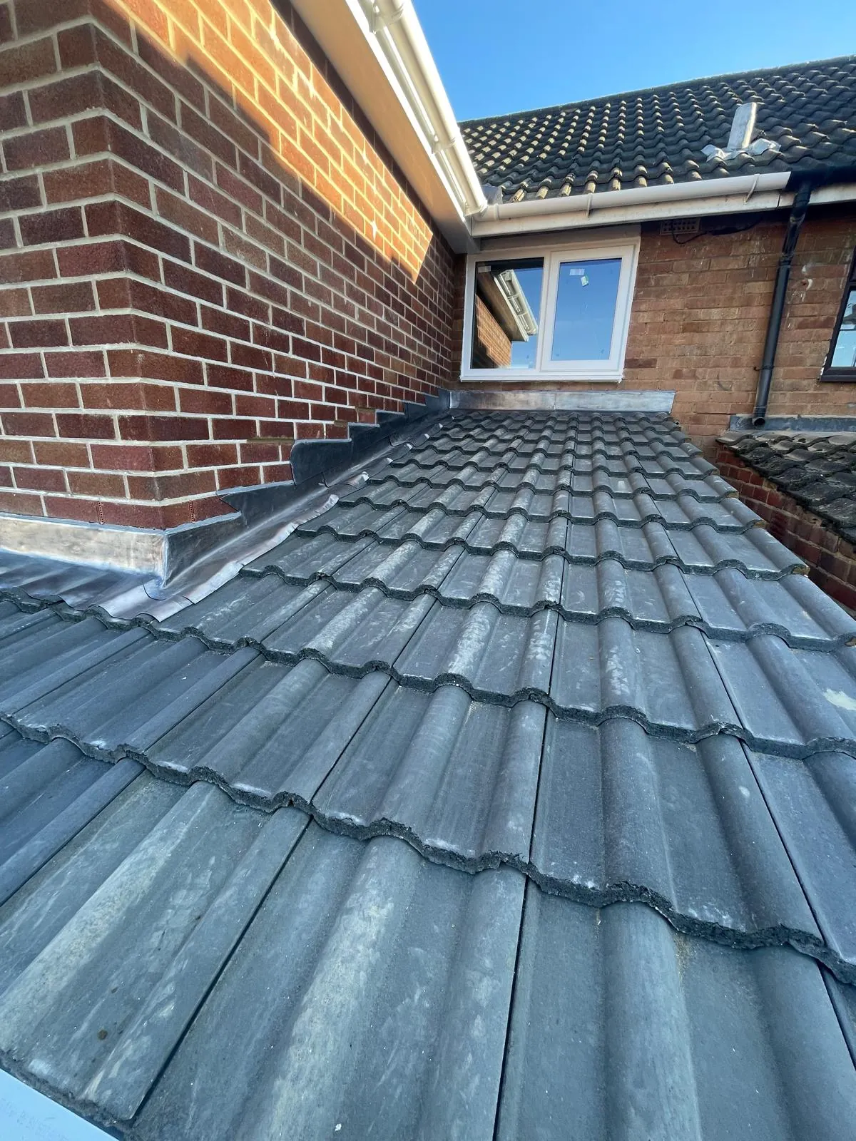 New lean-to roof tiled and lead-flashed against the house wall