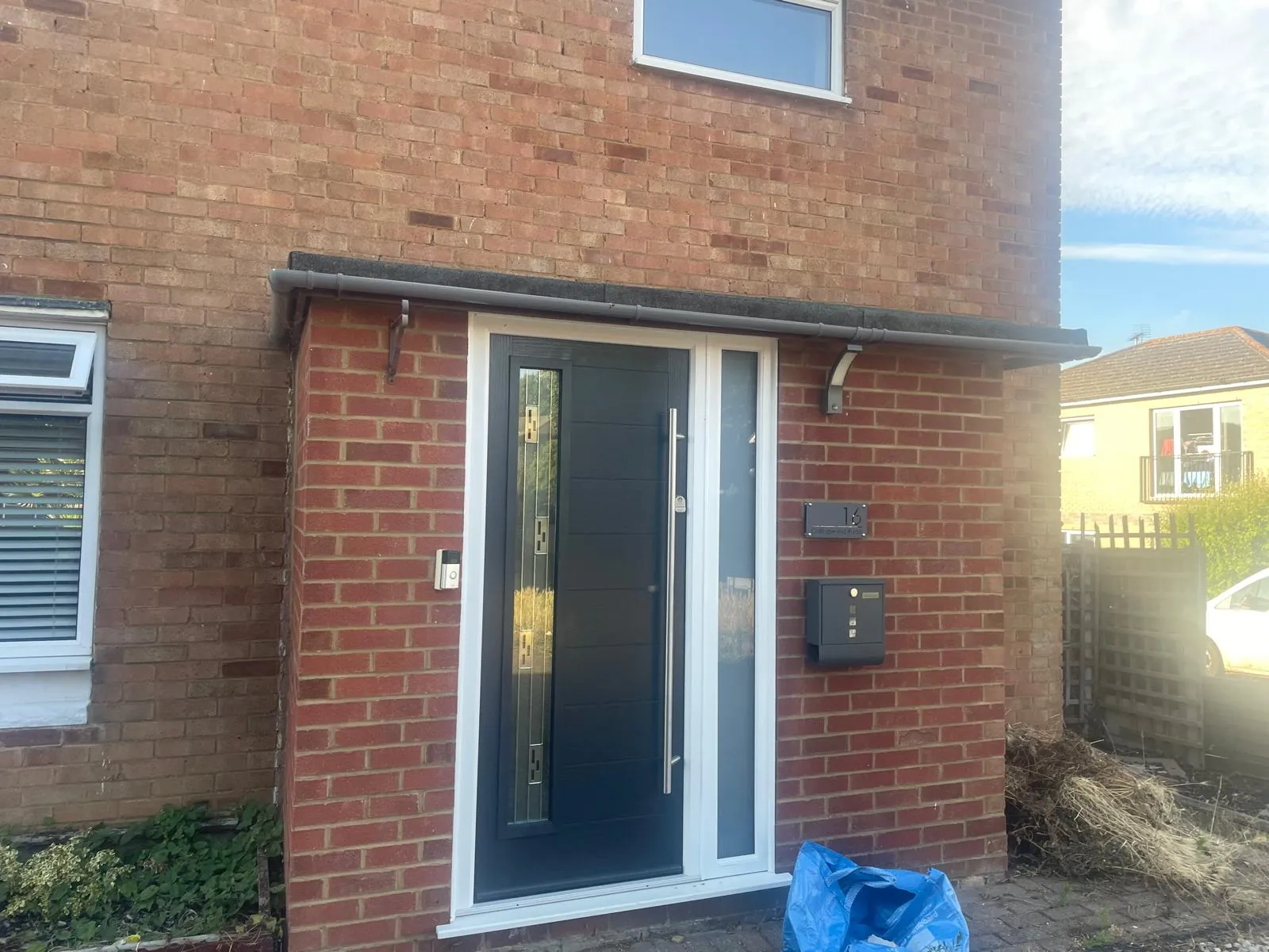 New composite front door under a tiled porch canopy