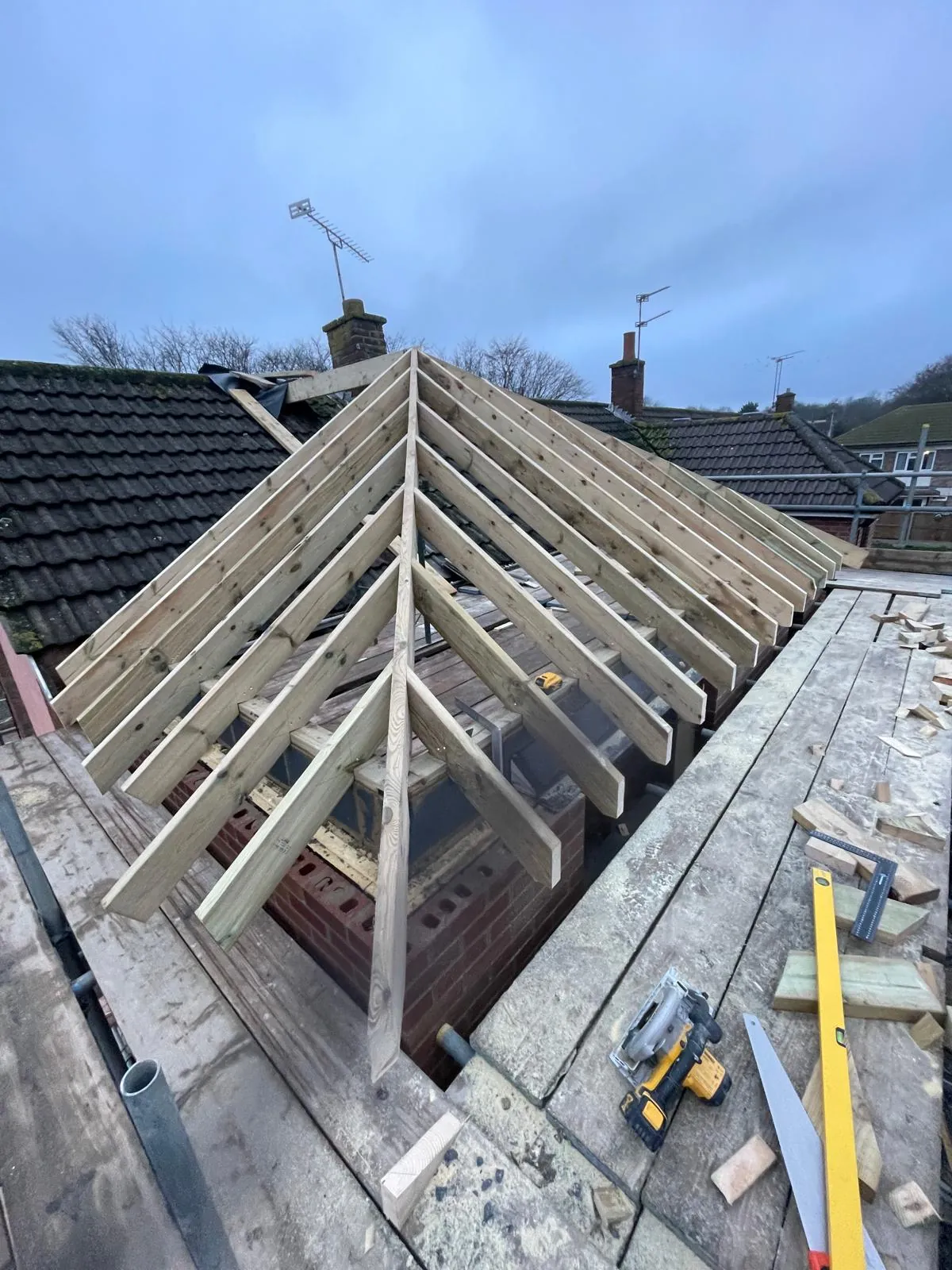 Cut timber rafters framing a new hipped roof