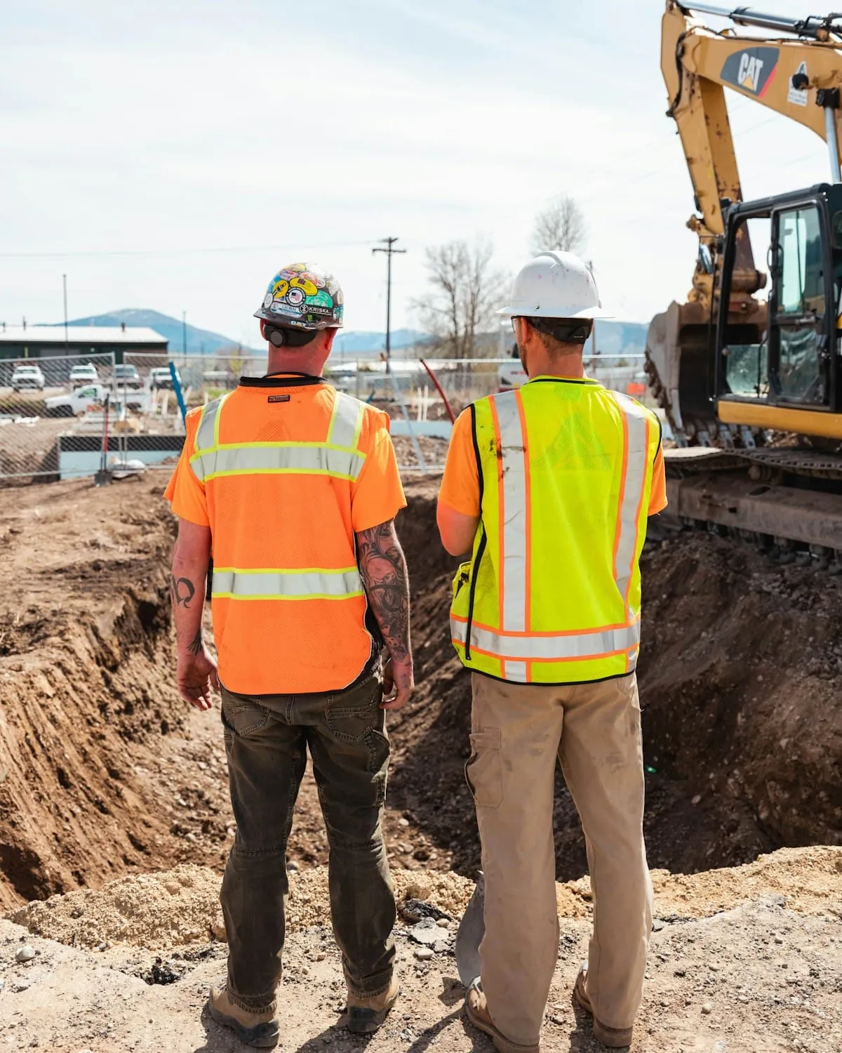 Builders reviewing groundworks together on site